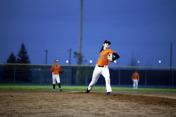 Young ball player in mid pitch well lit under powerful LED Lamps lighting Harold Page Field