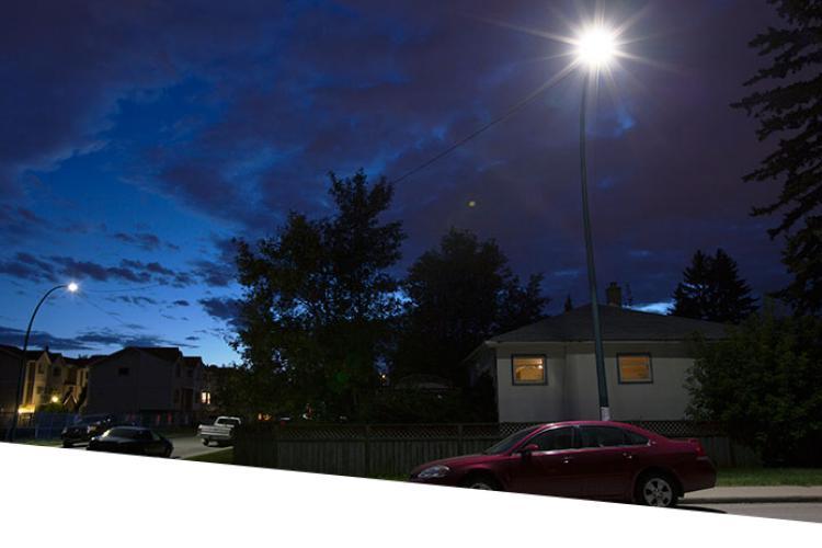 Residential neighborhood at night with street lamps